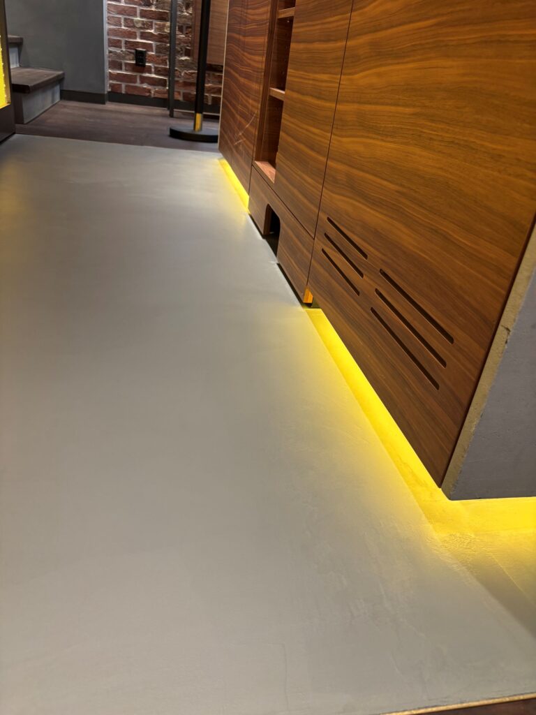 Beton ciré vloer met geïntegreerde LED-verlichting in high-end retailruimte