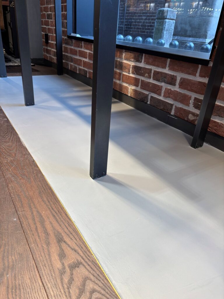Beton ciré vloer bij vitrines in Breitling boutique Den Haag