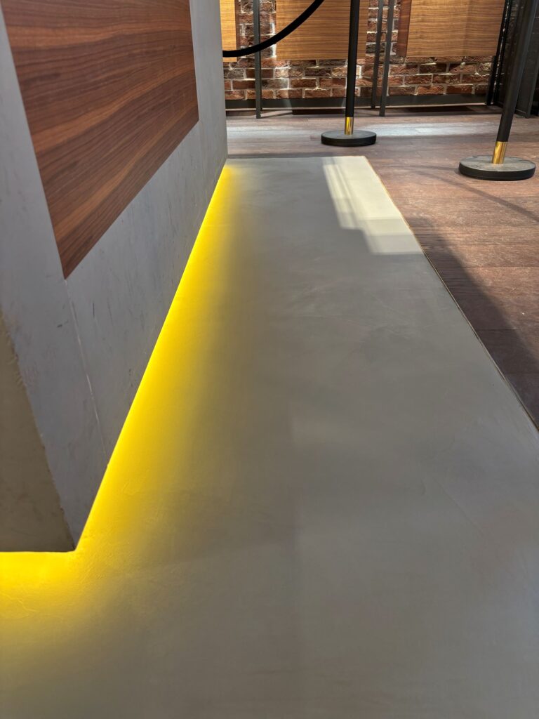 Strakke beton ciré vloerafwerking bij maatwerk wandmeubel